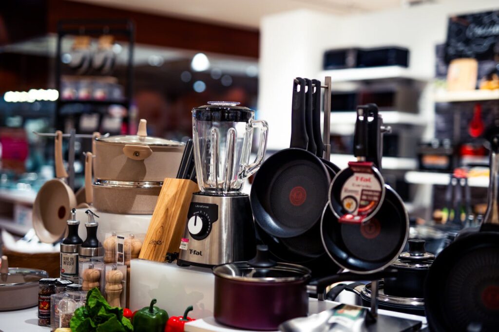 Various pots, pans, and a blender on display in a well-lit kitchenware retail section